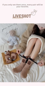 Detail of warm brown coral fleece socks featuring cute cartoon capybara bear patterns