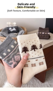 Detailed close-up of thick knitted wool socks with pine tree and deer jacquard patterns