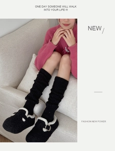 Detail of knit wool leg warmers with black plush slippers and faux fur trim styling