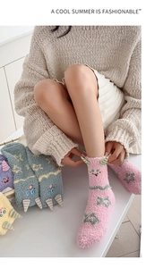Détail de chaussettes en polaire corail avec cornes de monstre et motifs d'étoiles