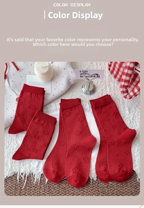 Detail of red crew socks with heart, star and floral jacquard patterns on white fleece