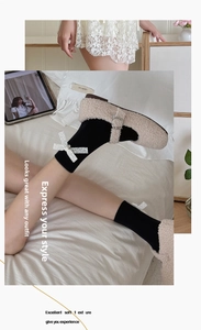 Détail de chaussettes mi-mollet noires avec nœud en dentelle blanche et maille fine