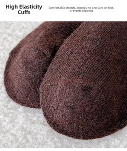 Close-up of thick wool knit texture on a dark brown thermal sock with ribbed cuff detail