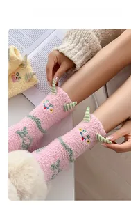 Gros plan de chaussettes monstres roses en polaire corail douce avec visage mignon