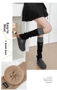 Detailaufnahme von Strick-Stulpen mit Logo und Filz-Clogs für den Winter-Look