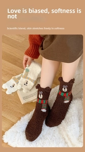 Close-up of coral fleece socks with 3D bear ears and embroidered facial details