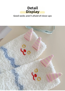 Gros plan de chaussettes en polaire corail blanche avec broderie mignonne et texture douce