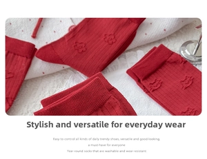 Detail of red knit socks featuring embossed 3D floral and lip patterns on cotton fabric