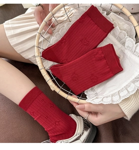 Close-up of vintage dark red ribbed cotton socks with 3D embossed knit patterns
