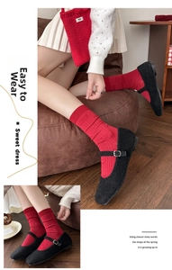 Detail of red knit socks featuring Luck embroidery and heart jacquard with Mary Jane shoes