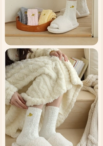 Close-up of cozy coral fleece socks with heart embroidery and plush open-toe slippers
