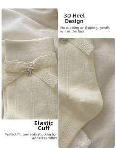 Détail de chaussettes crème avec nœud en dentelle et pendentif en métal Good Luck