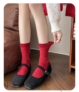 Detailed texture of red ribbed cotton socks with Lucky text and heart embroidery