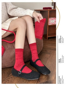 Detail of red crew socks featuring 3D embossed hearts and stars on rib-knit cotton fabric