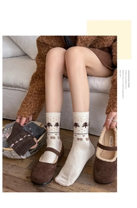 Close-up of thick Fair Isle knit socks with brown Nordic patterns on a warm beige base
