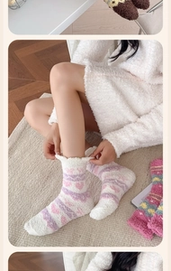 Détail de chaussettes thermiques douces avec cœurs roses, rayures mauves et pelucheuses