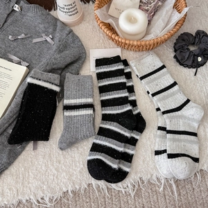 Winter thick wool blend striped socks in black and grey on cozy white faux fur rug