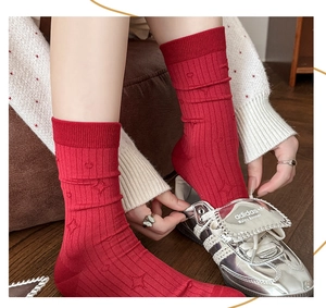 Detailed close-up of dark red crew socks featuring embossed stars and ribbed texture