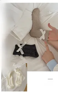 Texture détaillée de chaussettes en coton côtelé avec nœud élégant en dentelle blanche
