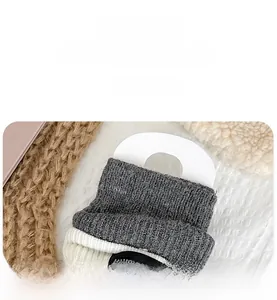 Nahaufnahme der Strick-Stulpen mit 'HAND MADE' Etikett und gerippter Textur