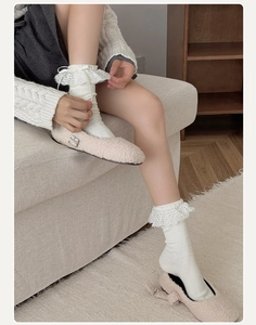 Dettaglio di calze bianche in maglia a costine con pizzo e fiocchi di nastro dolce
