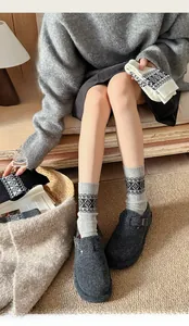 Detail of Nordic Fair Isle knit socks paired with wool felt slippers on cozy rug