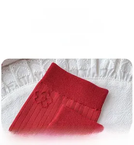 Detail of red ribbed knit sock featuring elegant 3D floral pattern and elastic cuff