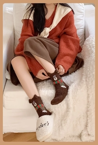 Close-up of brown coral fleece socks with 3D teddy bear ears and a red scarf design