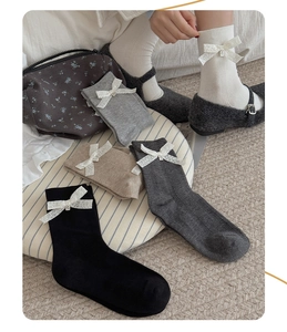 Détail de chaussettes en coton avec nœuds en dentelle et pendentifs au style JK rétro