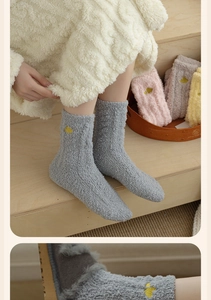 Detailed texture of thick coral fleece winter socks with heart embroidery and soft colors