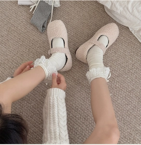Dettaglio di scarpe Mary Jane in pile beige con calze bianche in pizzo in stile vintage
