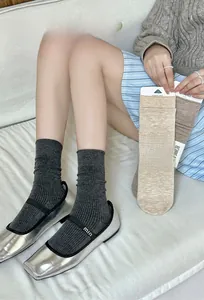 Dettaglio della maglia in lana di calze morbide nei colori grigio, beige e marrone