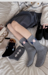 Détail de chaussettes vintage en laine à motifs de losanges gris et beige tricotés