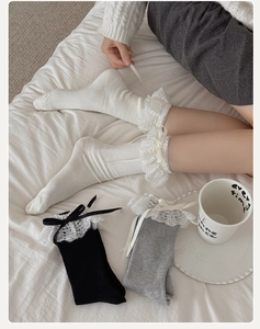 Dettaglio ravvicinato di calze dolci JK Lolita con pizzo delicato e fiocchi di nastro in raso