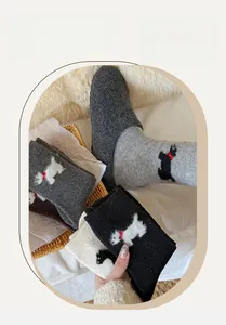 Gros plan de chaussettes en laine douillettes avec motif chien et chaussons en peluche