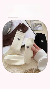 Close-up of knit cotton crew socks featuring delicate heart embroidery in multiple colors