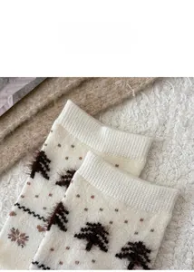 Detail of wool knit socks featuring a fuzzy 3D Christmas tree and brown polka dot patterns