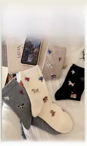 Detail of four pairs of warm winter wool socks with cute dog and tree jacquard patterns