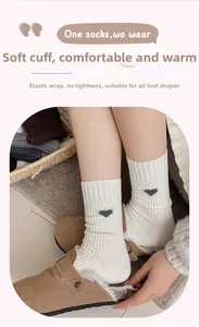 Detail of cream rib-knit mid-calf sock featuring black heart embroidery and elastic cuff