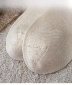 Close-up of the reinforced toe on creamy white knit wool socks with soft texture