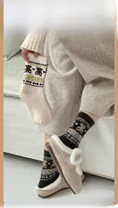 Detailed view of Fair Isle bear socks with jacquard heart patterns and thick wool texture