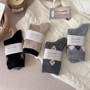 Lot de chaussettes en laine à losanges aux tons neutres sur un pull en maille