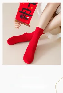 Detail showing red knitted mid-calf socks with vertical stripe texture and elastic cuff
