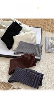 Detailed knit texture of warm cashmere-like mid-calf socks in various neutral tones