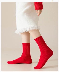 Close-up of red crew socks featuring a ribbed knit texture on a model wearing white fringe