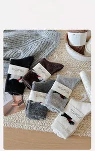 Détail de chaussettes en laine avec broderies d'animaux mignons en cinq couleurs