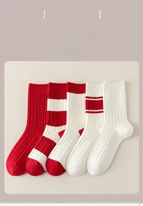 Detail of red and white striped thick knitted crew socks with cable knit texture