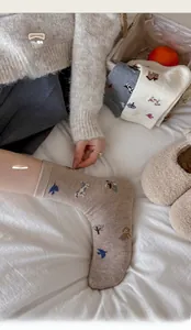 Detail of warm wool socks with cute dog and tree patterns in neutral earthy tones
