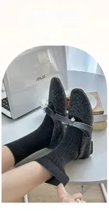 Detail of dark grey wool rib-knit socks paired with pearl velvet bow Mary Jane shoes