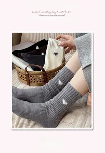 Detail of ribbed knit socks featuring delicate heart embroidery and high elastic cuffs